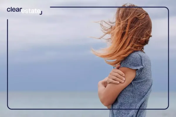 Woman looking at the ocean holding her arms