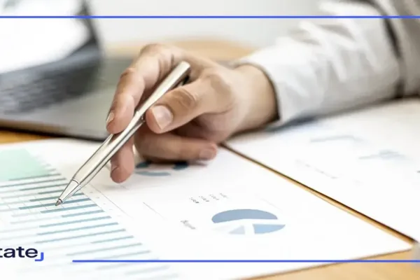 Businessman holding a pen pointing at a asset chart